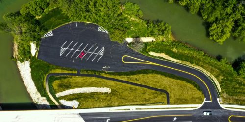 Aerial view of roadway construction with parking lot and bridge access